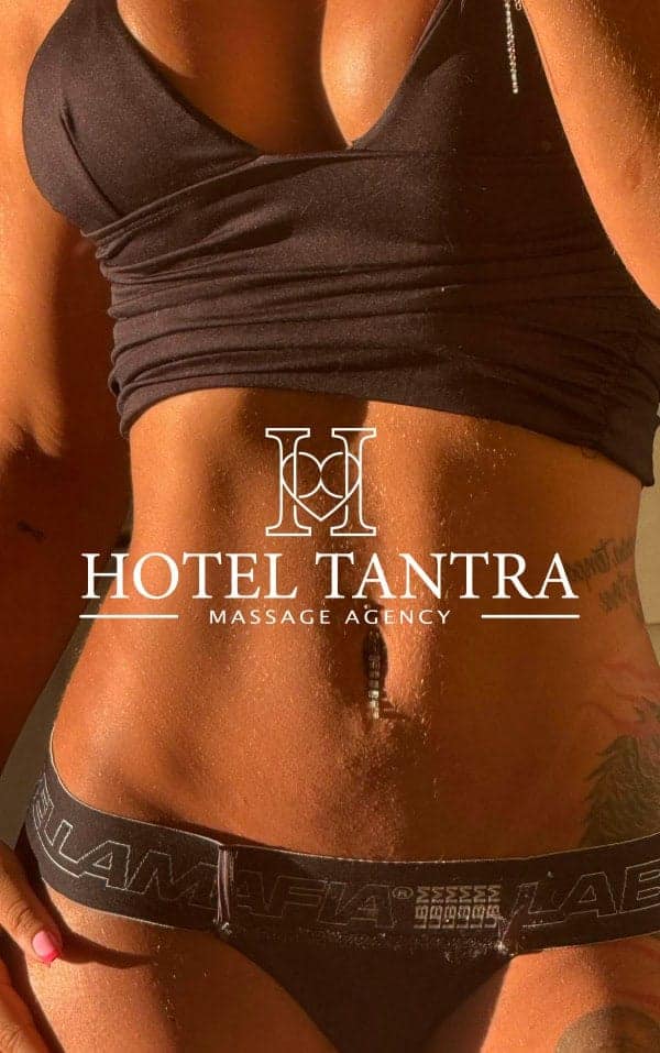 Close-up of a woman's midsection in a black crop top and black underwear, with 'Hotel Tantra Massage Agency' logo overlay on the abdomen.